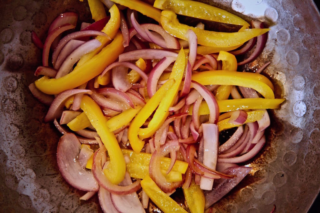 Mushroom Saltado in the making red onion and yellow bell pepper. 