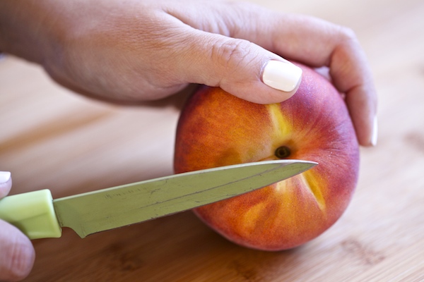 a peach being cut for salad
