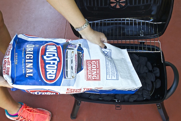 pouring Kingsford charcoal in grill