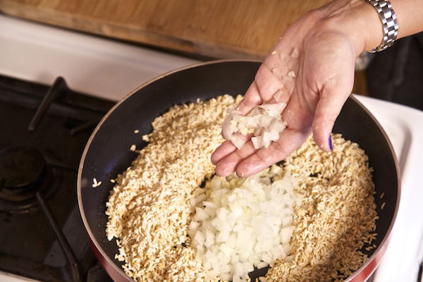 Adding chopped onion and minced garlic to rice