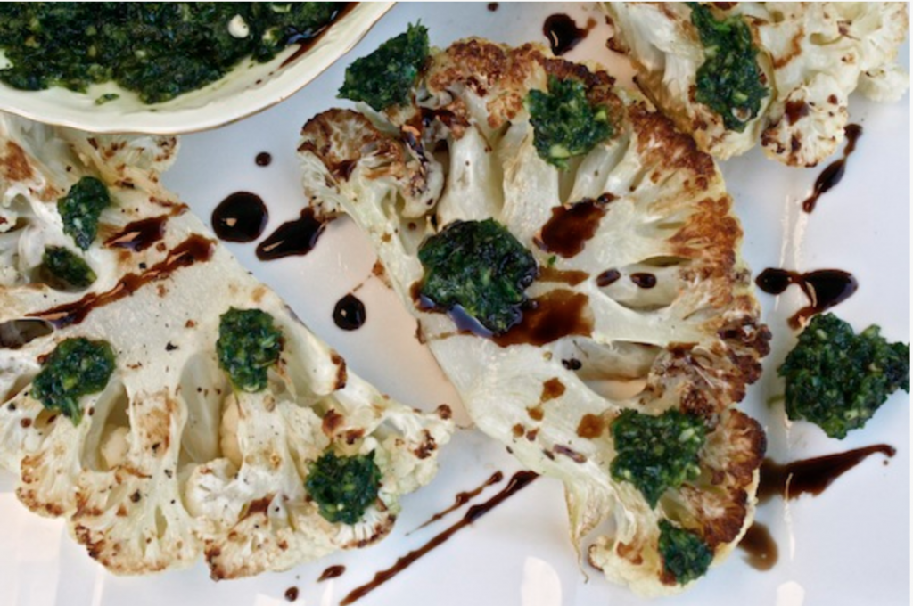 Roasted Cauliflower Steak Drizzled In Jalapeno Cilantro Chimichurri is a great vegan dish to make quickly 