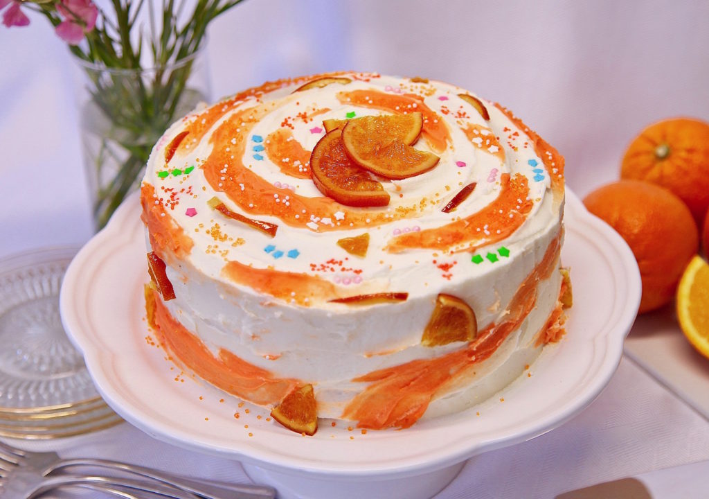 Moist Layer Orange Cake With Buttercream Frosting on a cake stand