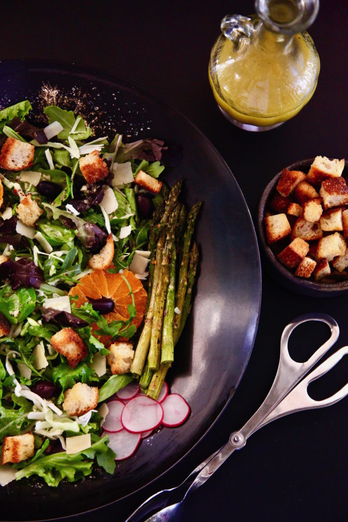 Roasted Asparagus Spring Salad with a side of croutons and salad dressing. 